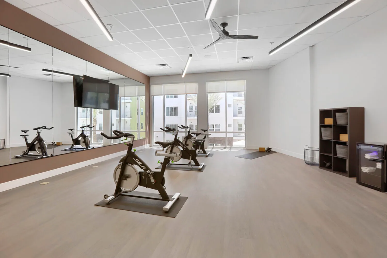 Garrett Uptown spin cycle studio with SILK indoor cycling bikes, floor-to-ceiling mirrors, ceiling fan, and natural light in Chandler, AZ