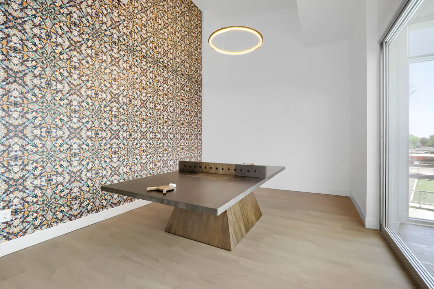 Garrett Uptown clubhouse ping pong table with designer wood base, ornate tile accent wall, and ring pendant light in Chandler, AZ