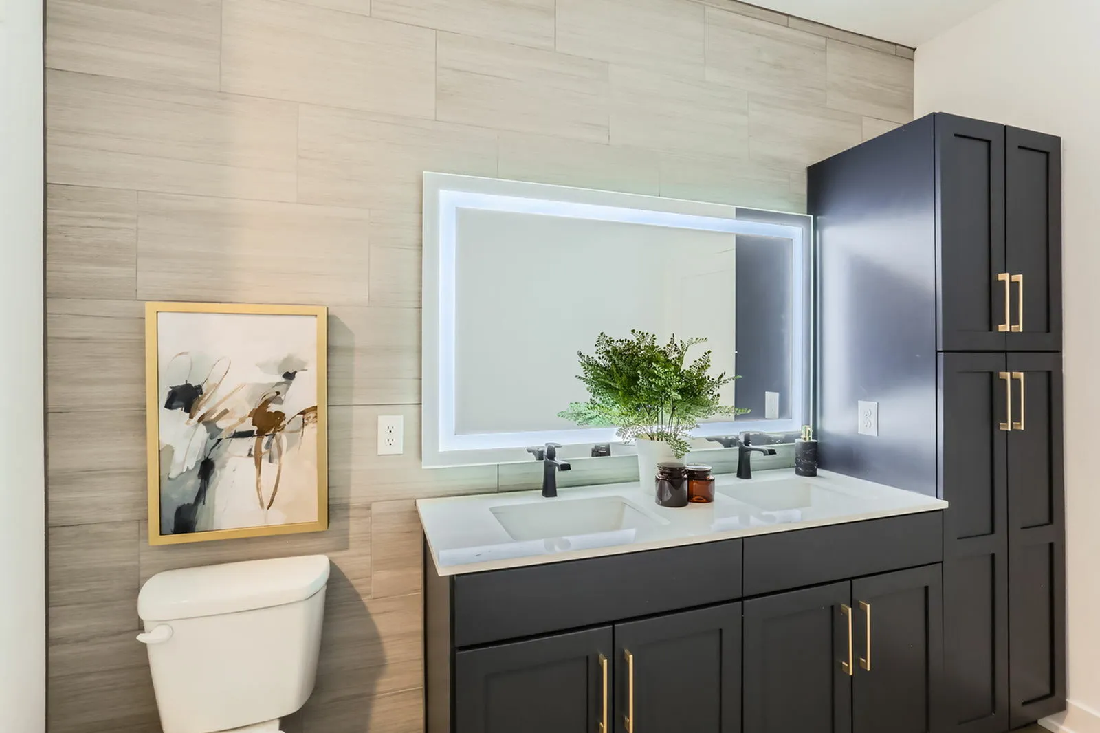 LED-backlit vanity mirror with touch controls above bathroom sink at Ara Townhomes & Flats in Castle Rock, Colorado