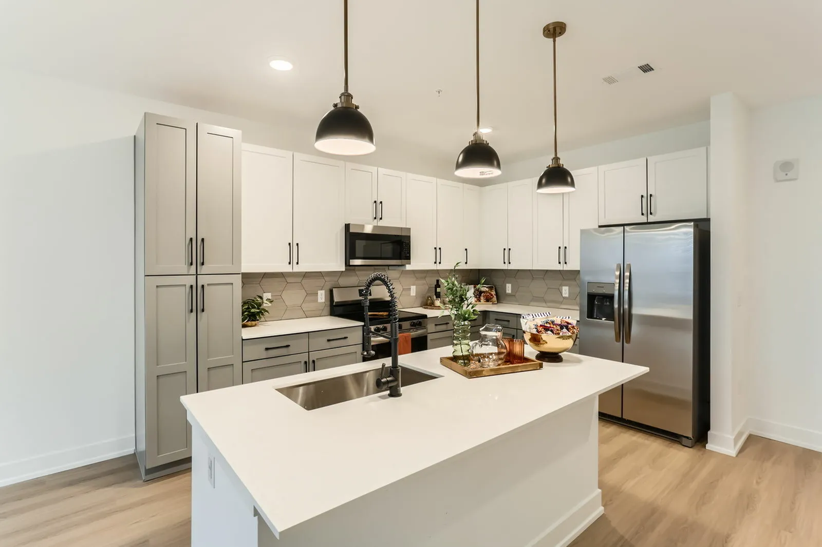 Quartz kitchen island with sink and bar seating at Ara Townhomes & Flats in Castle Rock, Colorado