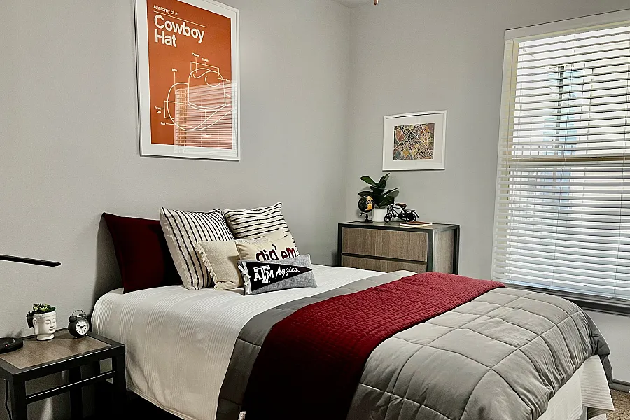 Cozy bedroom with modern decor, featuring a neatly made bed with plush pillows, stylish wall art, and abundant natural light streaming through large windows.