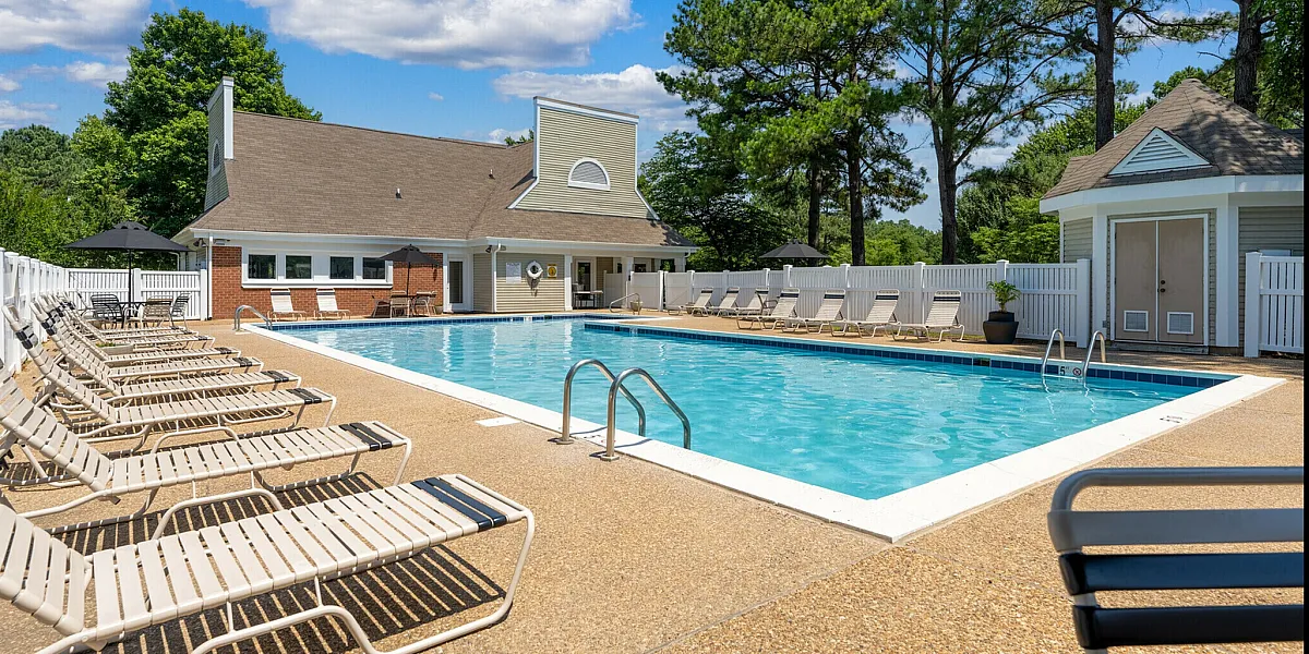 Charming outdoor pool area with loungers and lush greenery, perfect for relaxation and leisure.