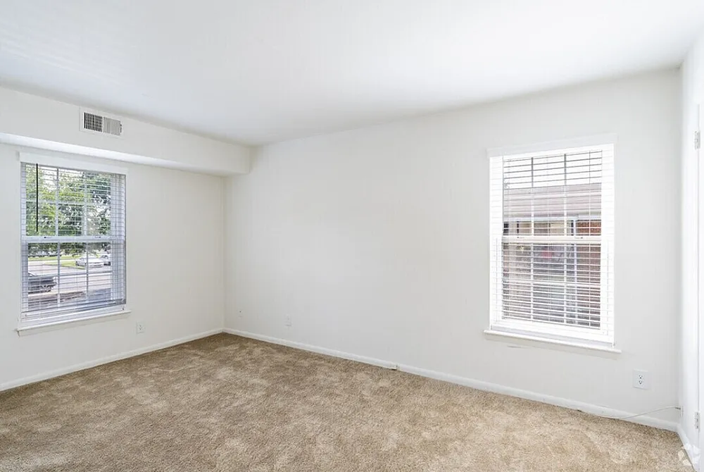 Bright, airy room featuring plush carpeting and large windows with abundant natural light.