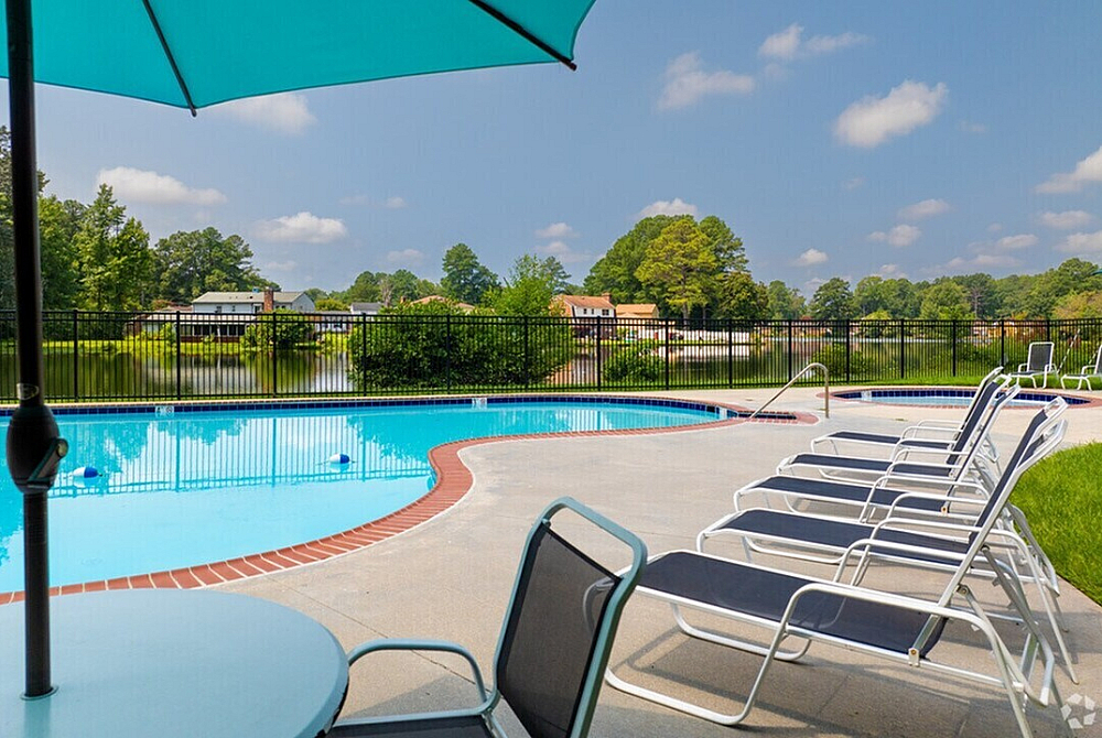 Inviting outdoor pool area with comfortable loungers and scenic views of lush greenery, perfect for relaxation.