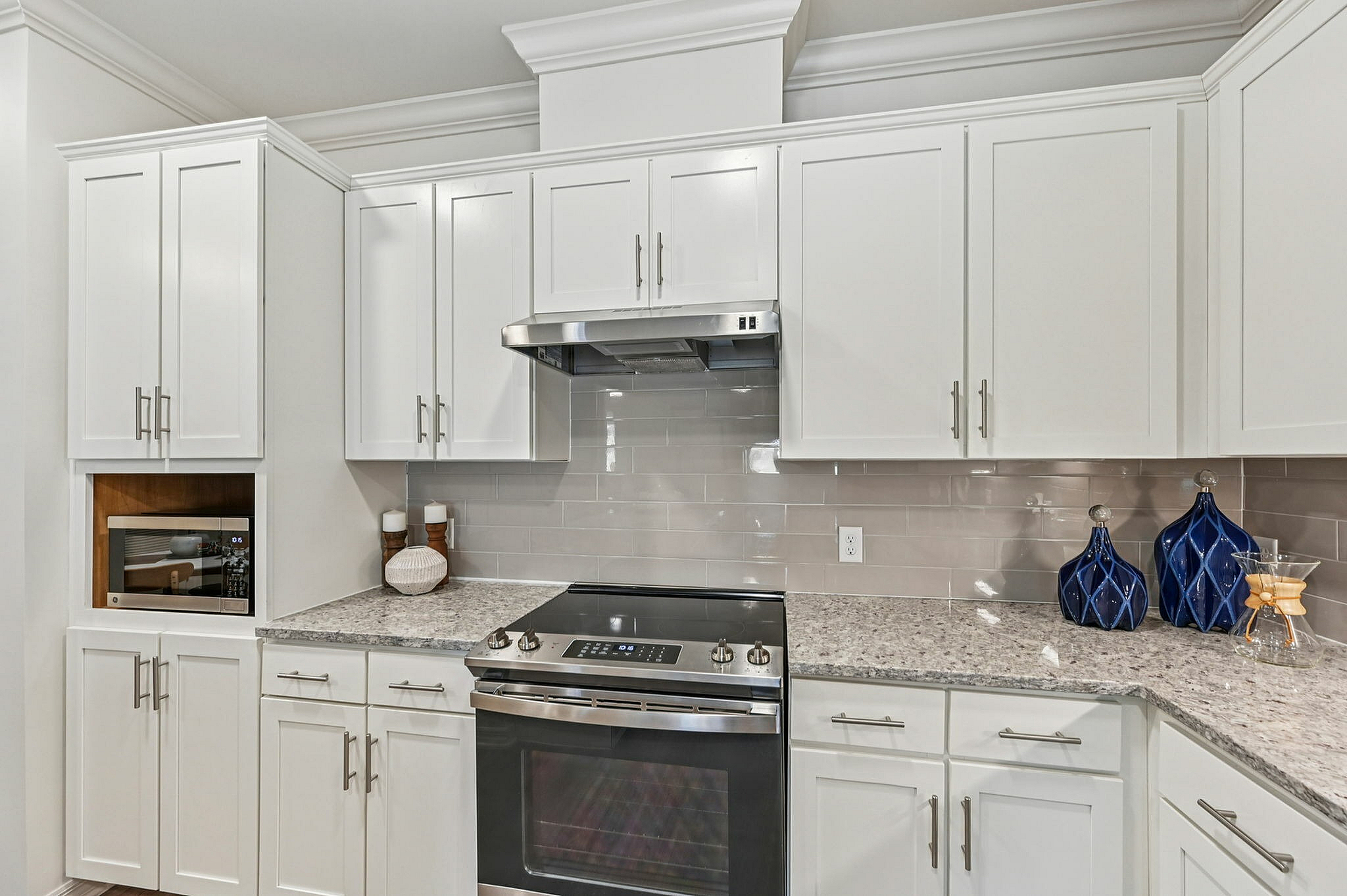 Bright, modern kitchen with sleek white cabinetry, stainless steel appliances, and elegant granite countertops.