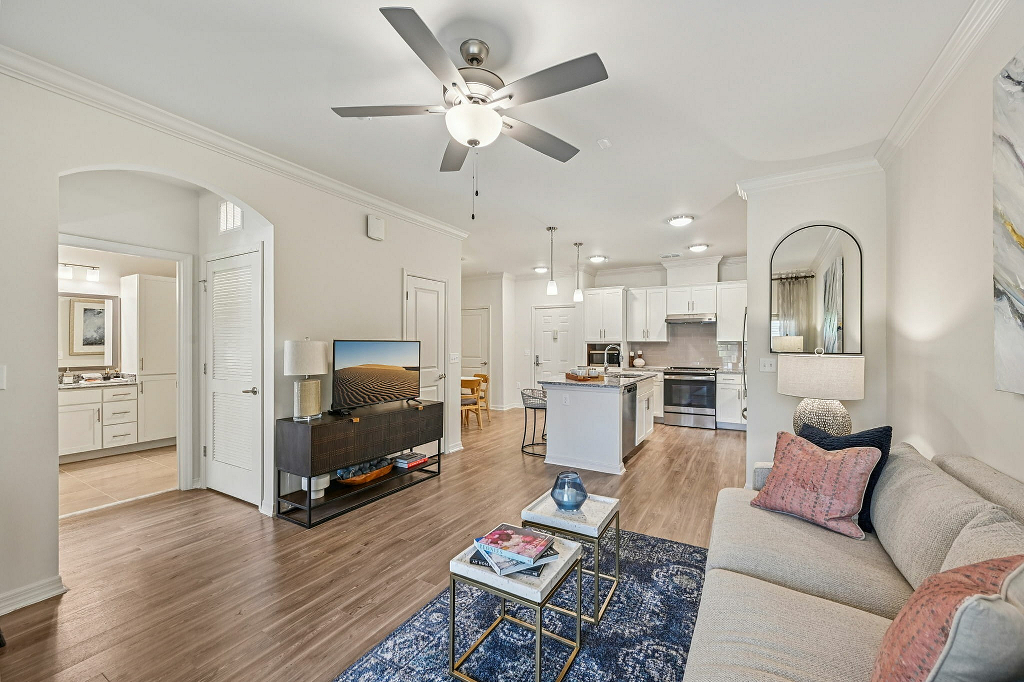 Bright and inviting open-concept living room with modern kitchen, featuring stylish furniture and elegant decor.