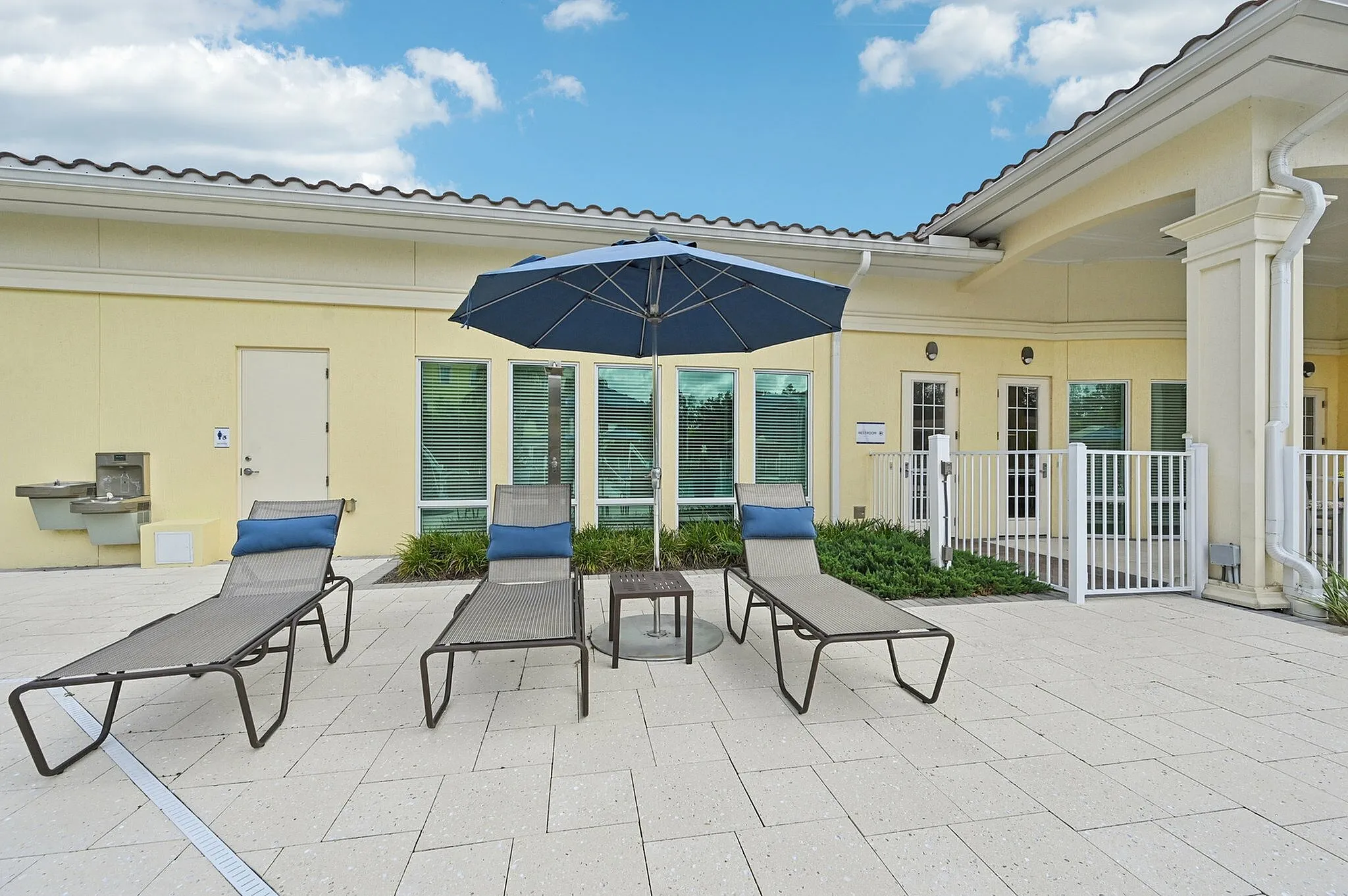 Inviting outdoor space with elegant lounge chairs, a stylish umbrella, and scenic views, perfect for relaxation and leisure.