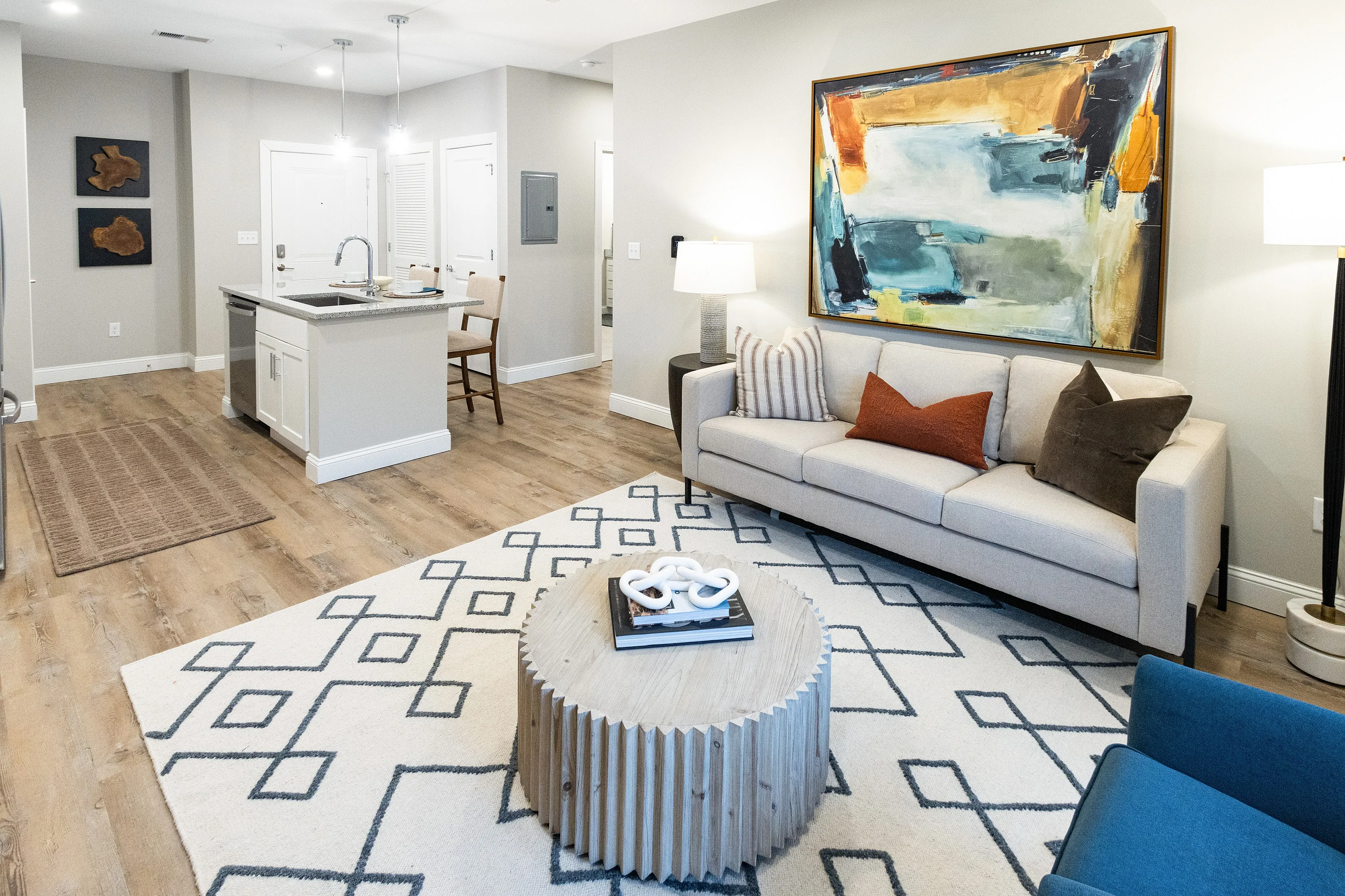 Inviting living room with cozy bedding, elegant decor, and a spacious walk-in closet, featuring natural light and warm wood flooring.