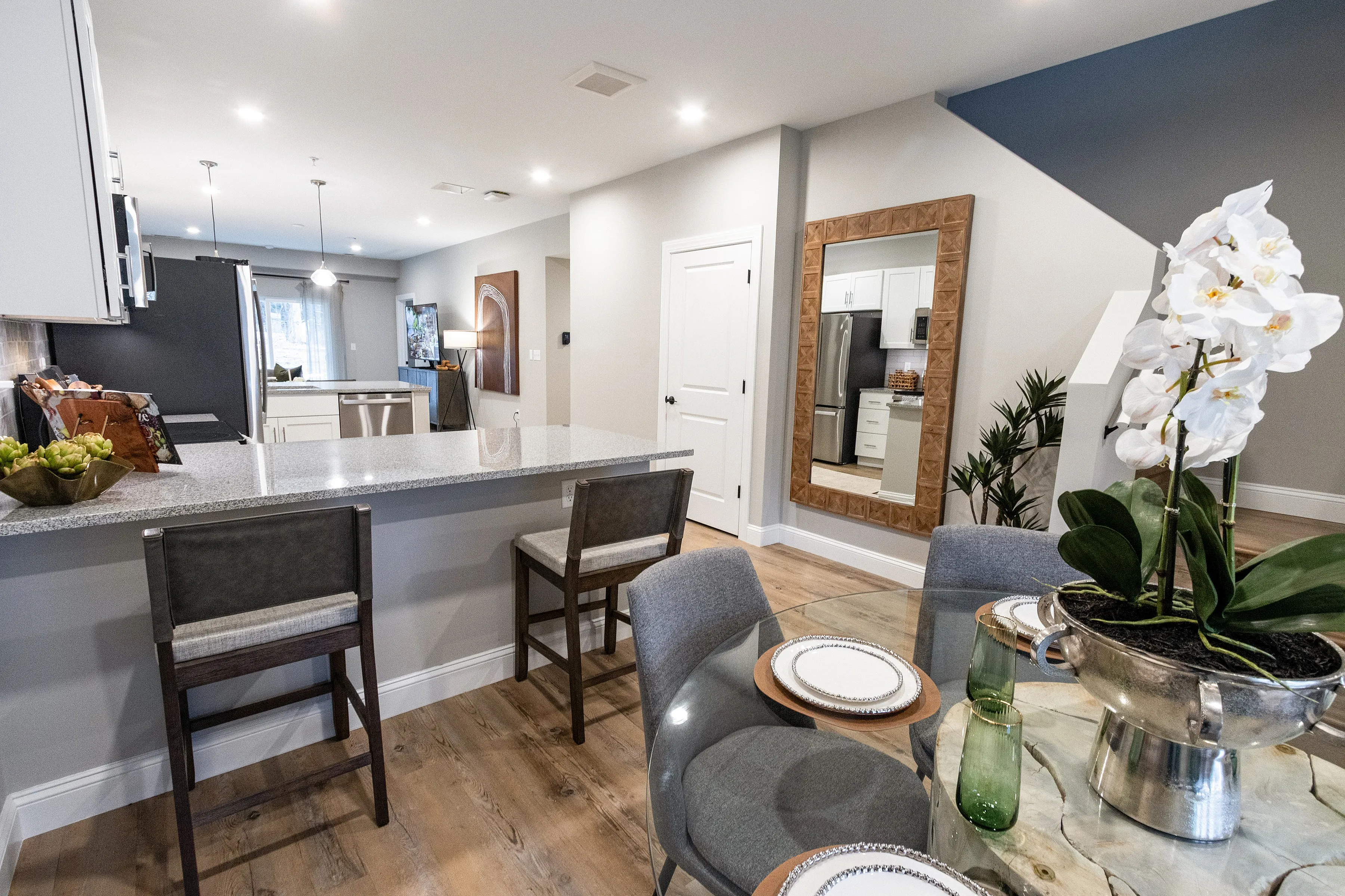 Inviting bedroom with cozy bedding, elegant decor, and a spacious walk-in closet, featuring natural light and warm wood flooring.