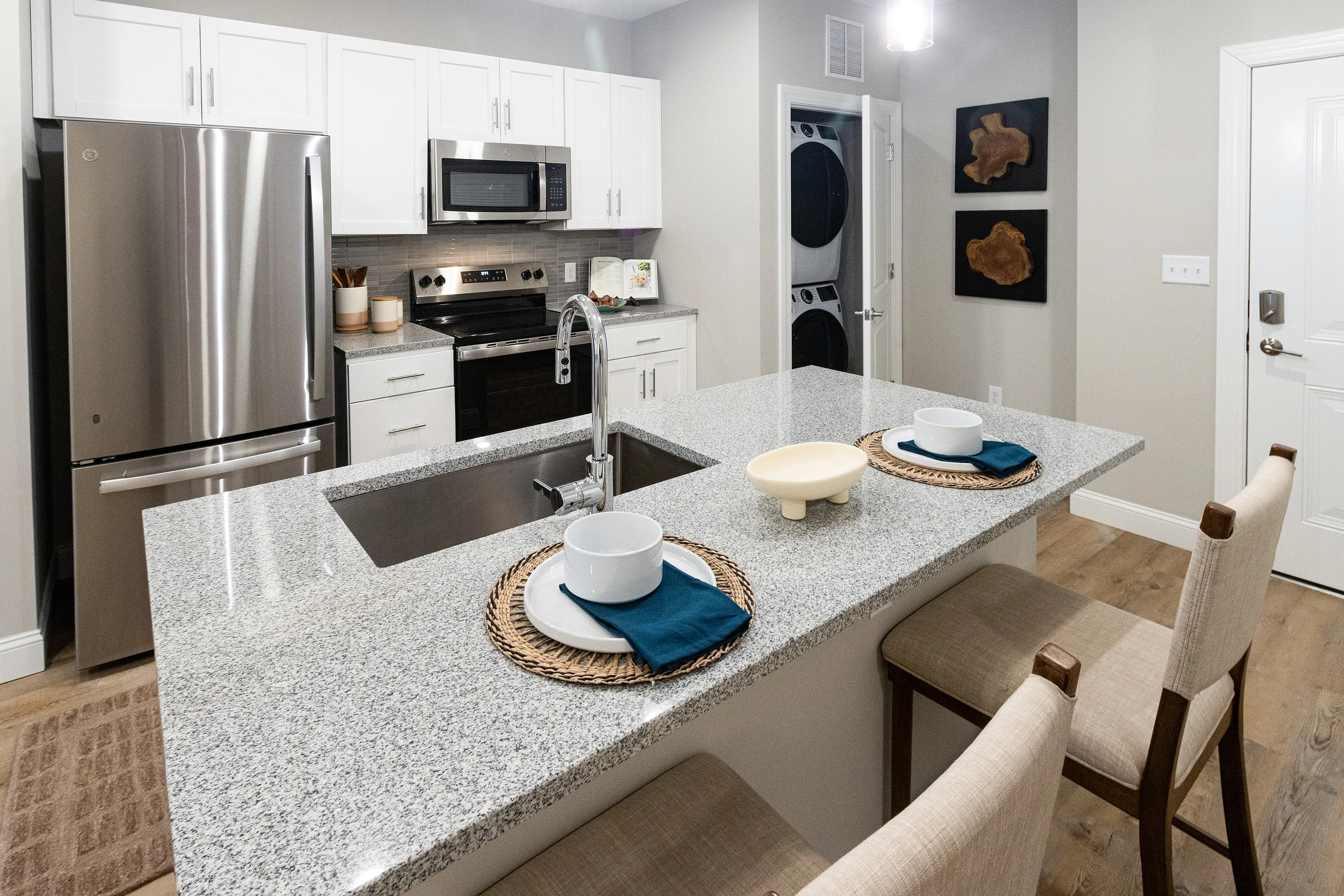 Chic modern kitchen with elegant granite countertops, stainless steel appliances, and cozy dining setup.
