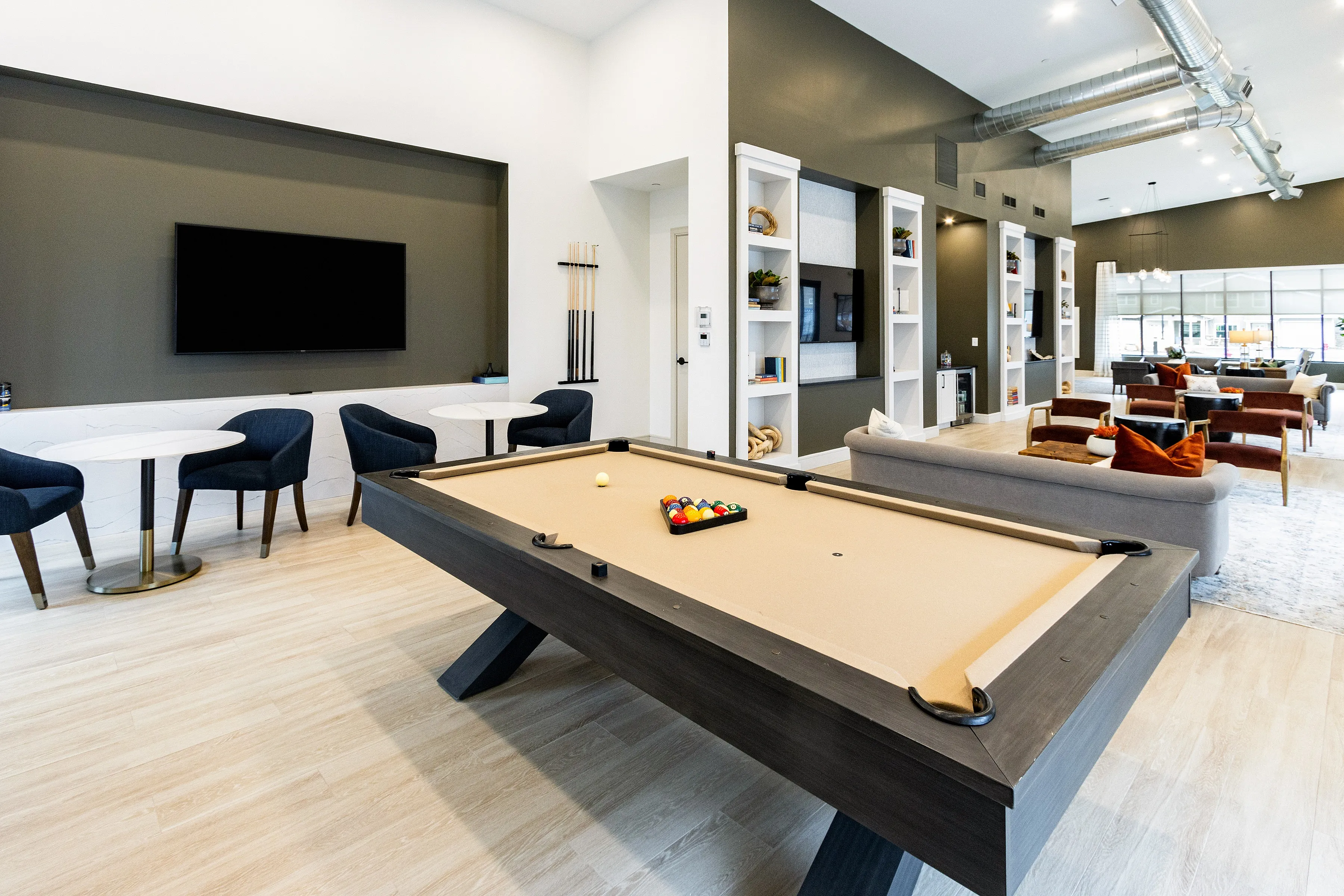 Modern and inviting recreation room featuring a stylish pool table, cozy seating area, and elegant decor perfect for entertainment and relaxation.