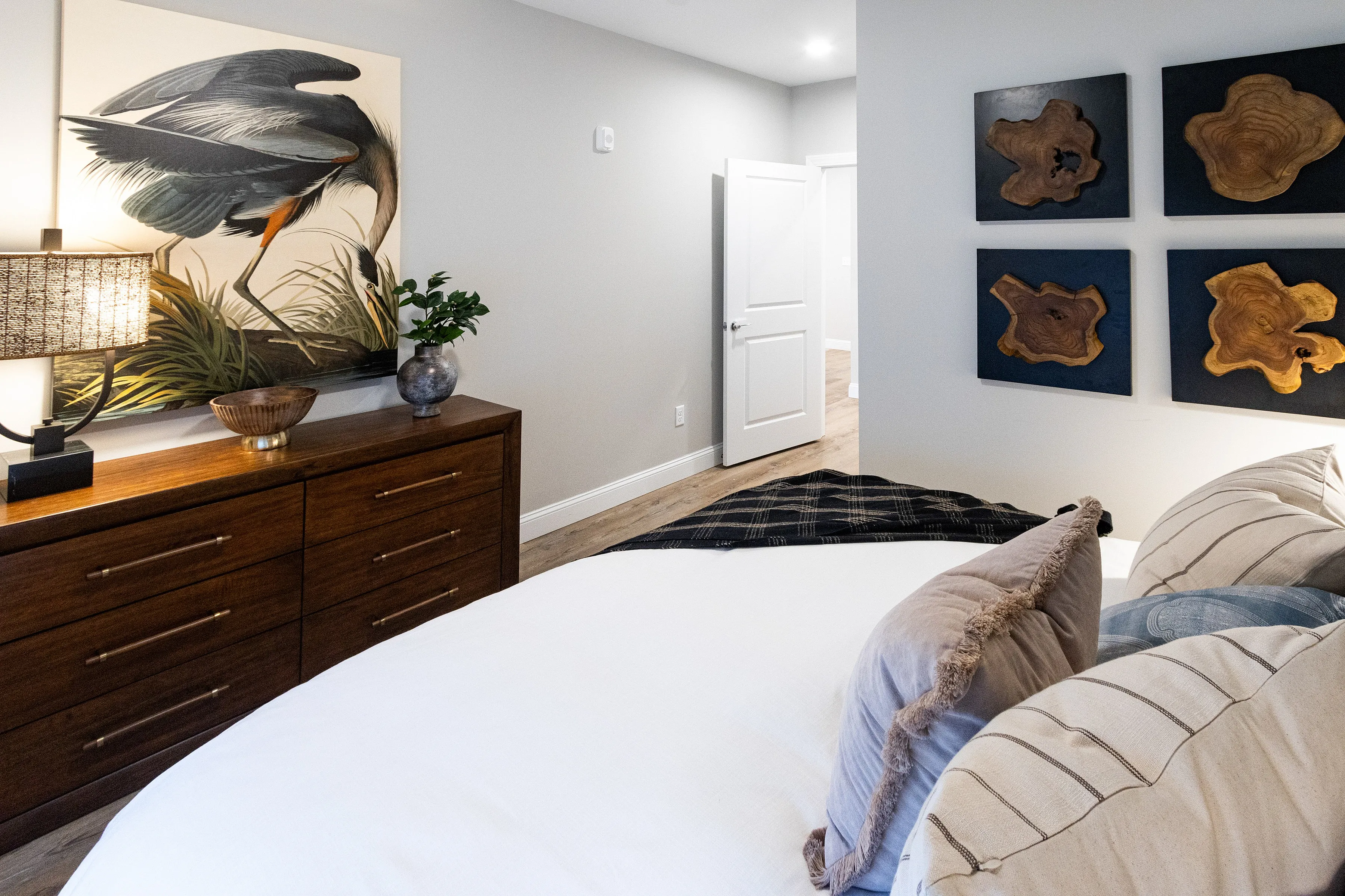 Luxurious bedroom featuring modern decor, elegant wooden dresser, and artistic wall accents for a cozy atmosphere.