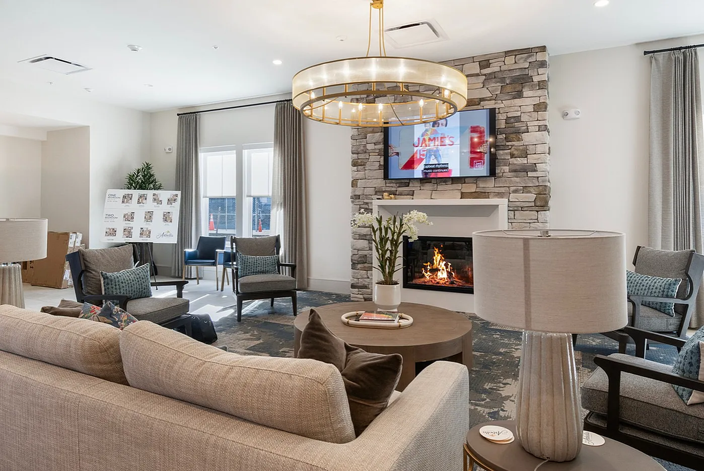 Inviting living room with stylish modern decor, featuring a cozy fireplace, elegant chandelier, and plush seating, perfect for relaxation and entertainment.