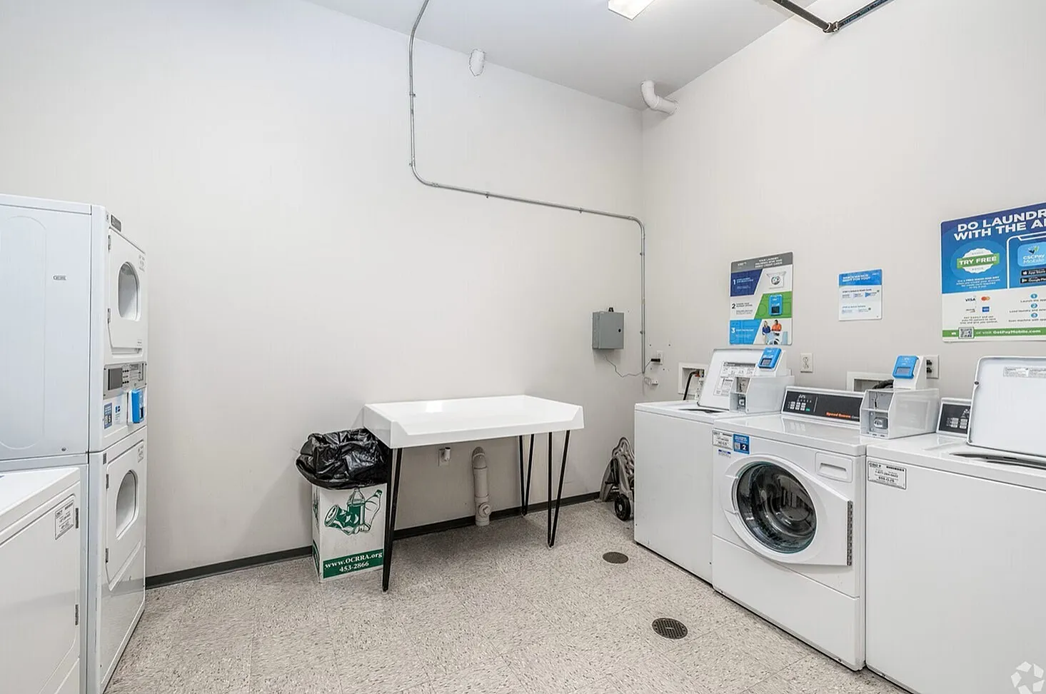 Bright and spacious laundry room with modern washers and dryers, perfect for efficient and convenient laundering.