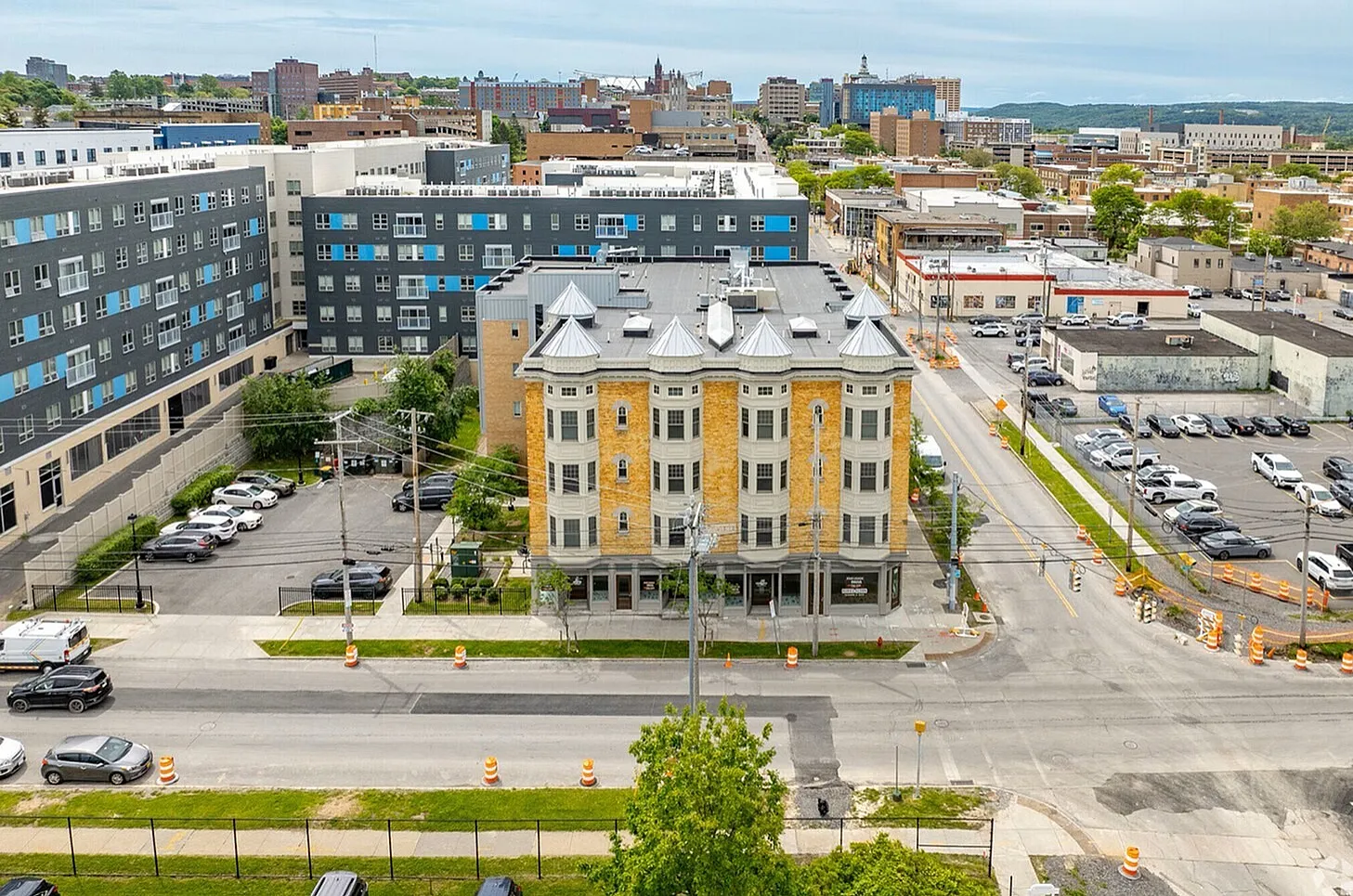 Charming urban apartment building with unique turret design, surrounded by vibrant cityscape and conveniently close to local amenities.