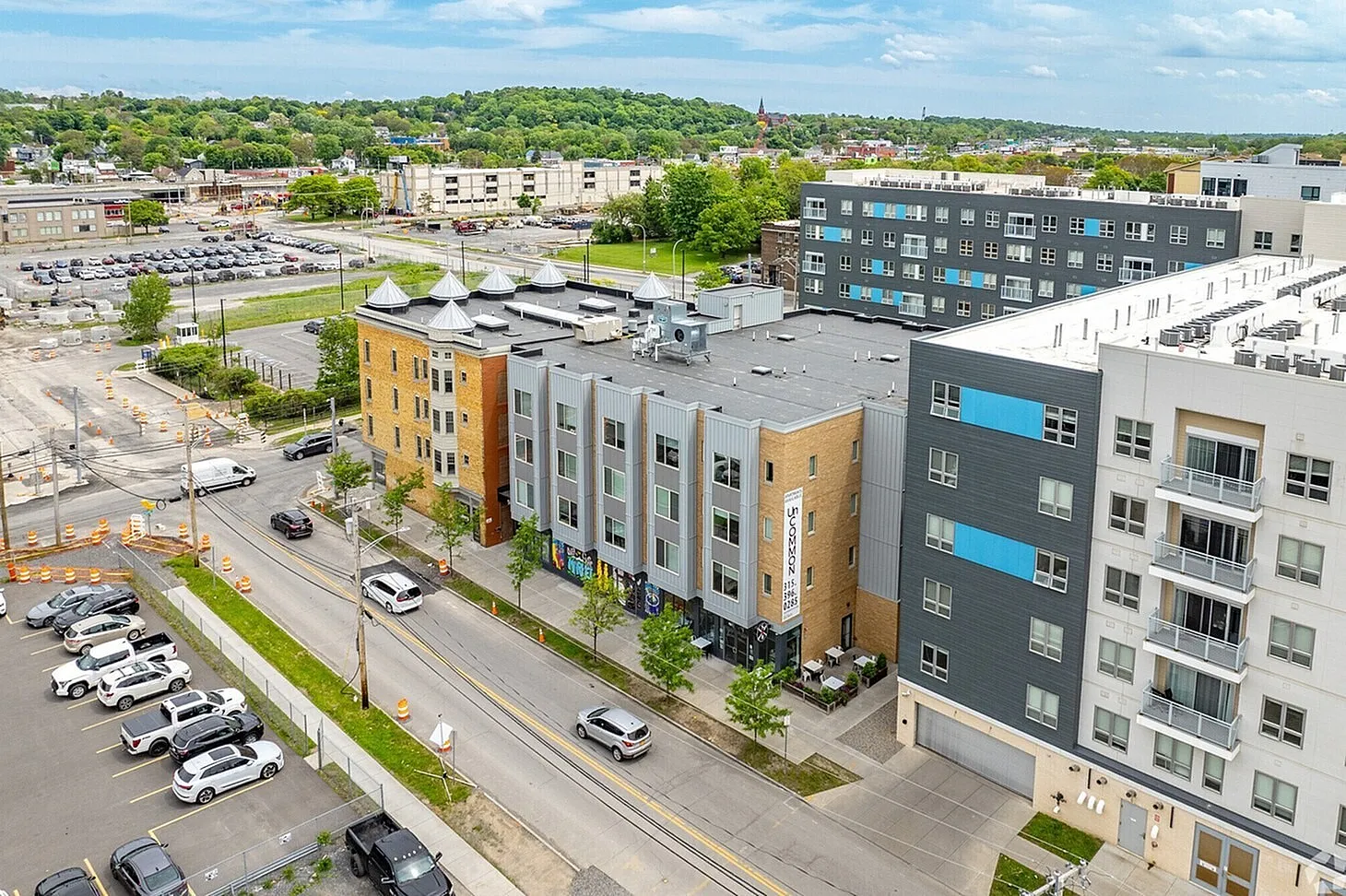 Charming urban apartment complex with modern design, nestled in a vibrant neighborhood with lush green surroundings and ample parking.