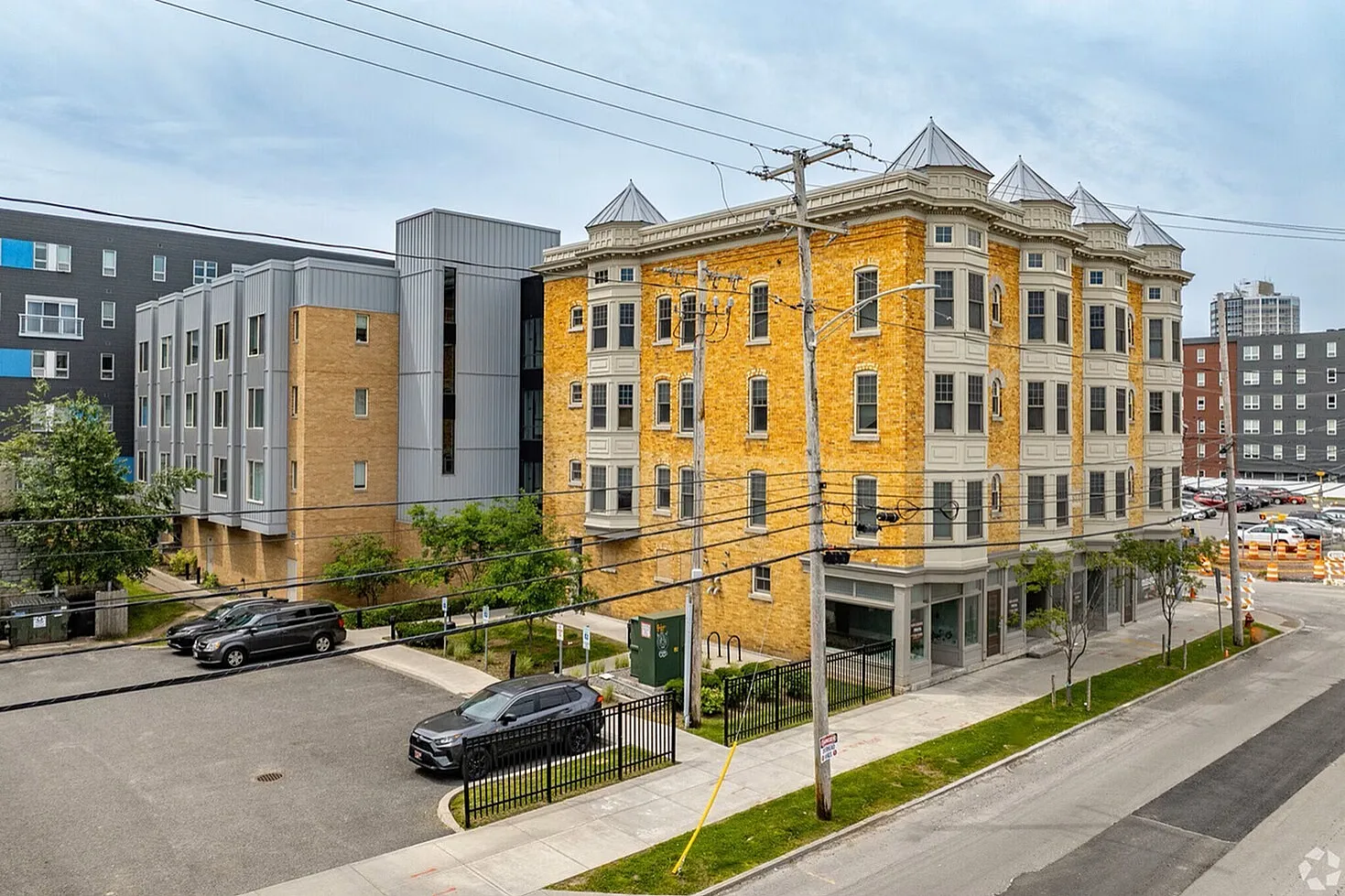 Charming urban apartment building with unique architecture, featuring striking yellow brick facade and modern design elements, surrounded by vibrant cityscape.
