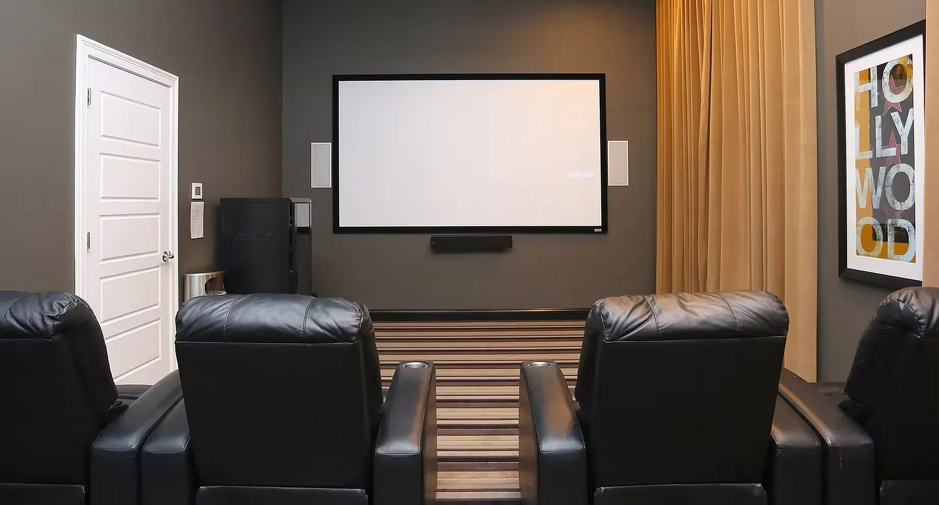 Luxurious home theater with comfortable leather seating, large screen, and stylish decor.