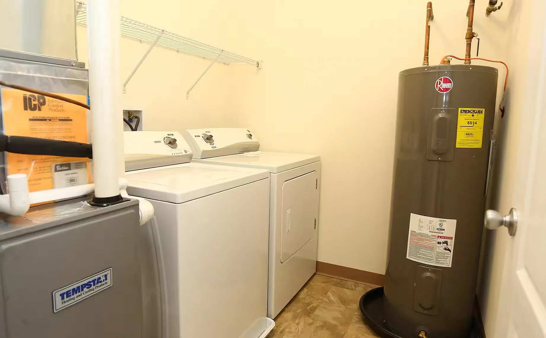 Bright laundry room featuring modern washer and dryer, efficient utility setup with water heater.