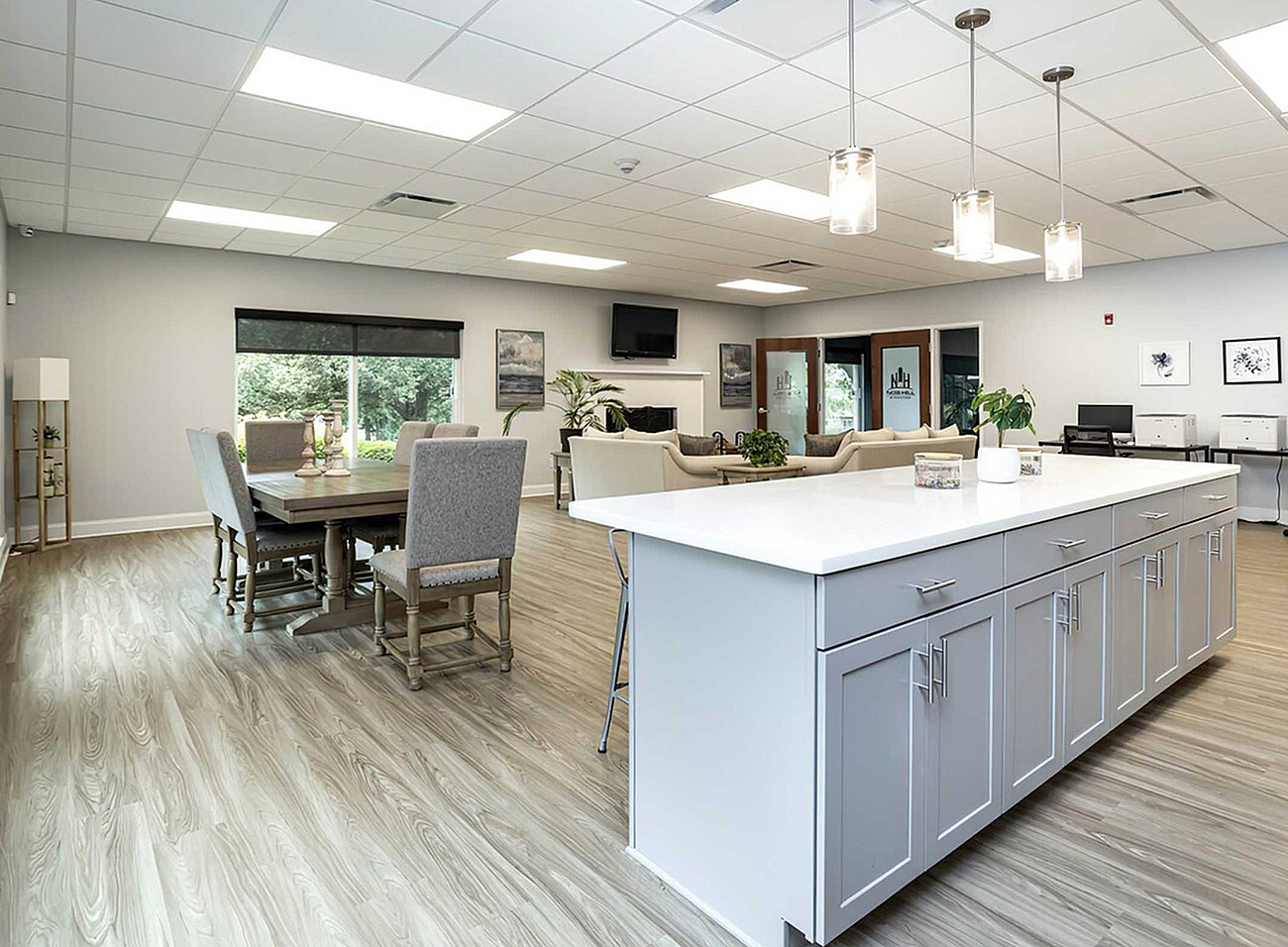 Bright and spacious open-concept apartment with a modern kitchen island, elegant dining area, and inviting lounge space overlooking scenic greenery.