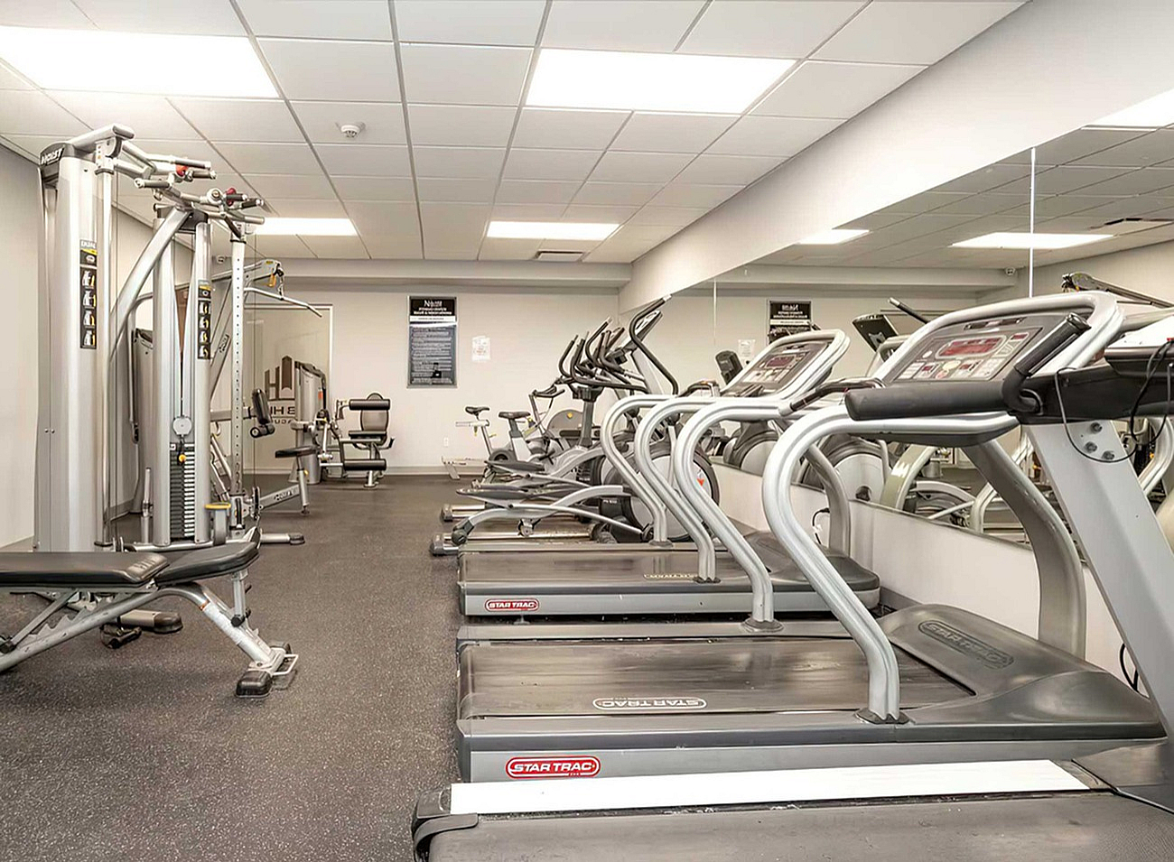 Modern fitness center with state-of-the-art equipment, including treadmills and strength training machines, ideal for a healthy lifestyle.