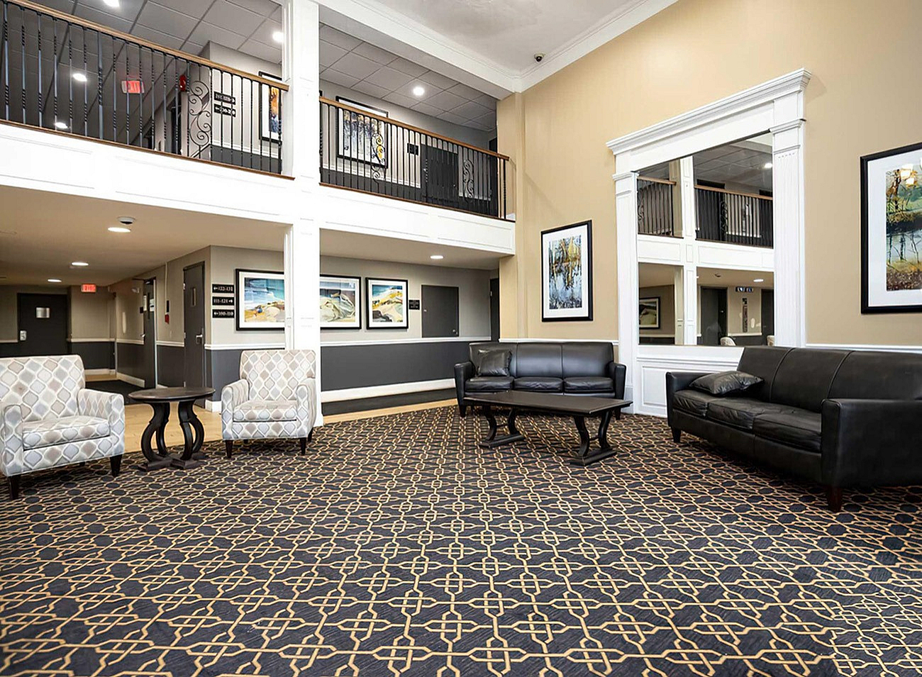 Elegant apartment lobby with sophisticated seating, modern artwork, and a striking patterned carpet.