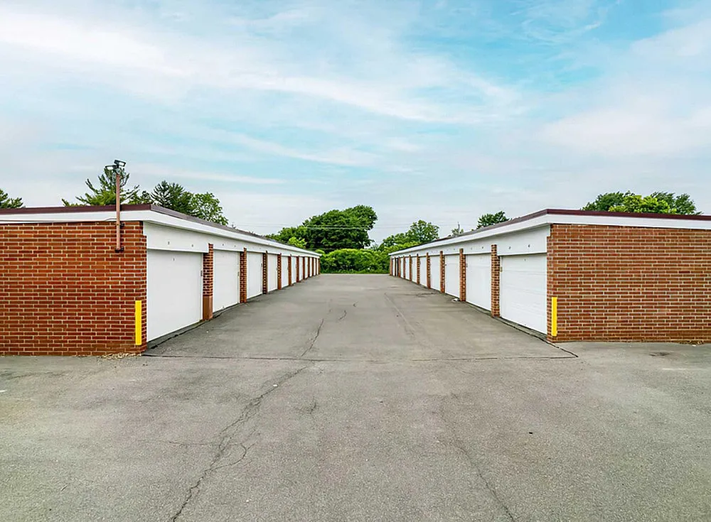 Expansive brick storage units offering ample space and secure access, surrounded by lush greenery.