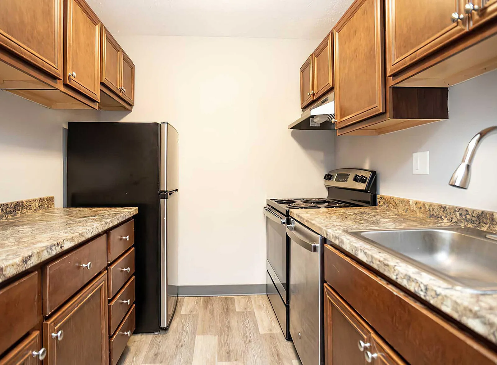 Contemporary kitchen with sleek stainless steel appliances, elegant wood cabinets, and chic granite countertops.
