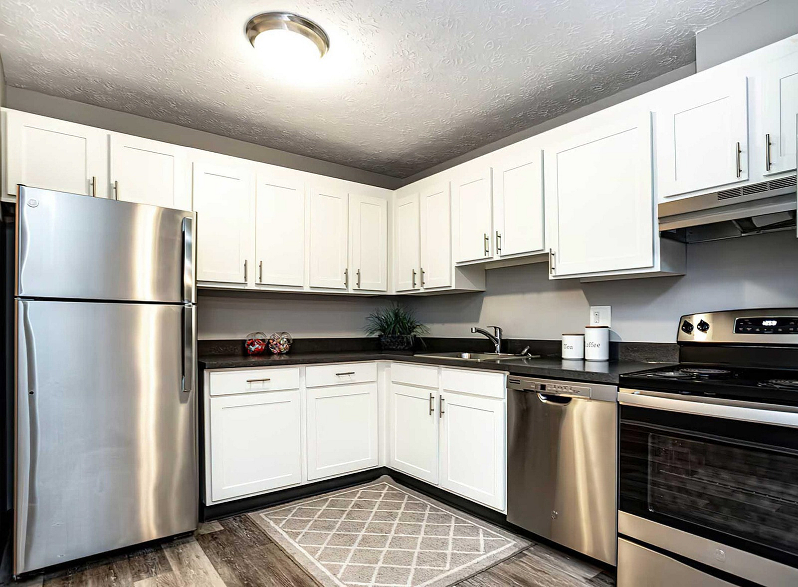 Modern kitchen featuring sleek stainless steel appliances, elegant white cabinetry, and a cozy countertop space.