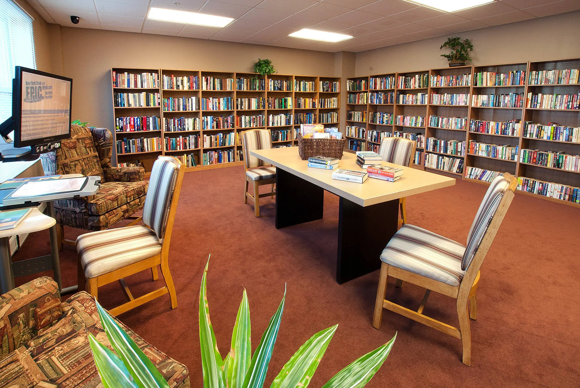 Inviting library space with elegant bookshelves, comfortable seating, and a central reading table, perfect for study or relaxation.