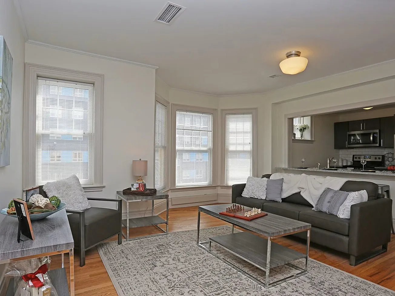 Inviting living room with modern decor, featuring plush seating, elegant hardwood floors, and ample natural light flowing through large windows.