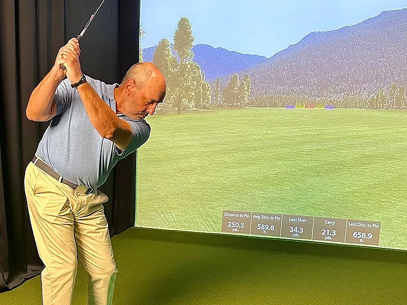 Modern indoor golf simulator room with plush seating and state-of-the-art virtual golfing setup, perfect for recreation and relaxation.