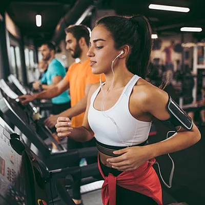 Vibrant fitness center with modern treadmills and energetic individuals enjoying a workout.