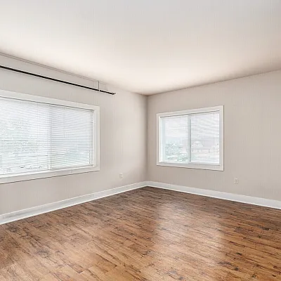 Bright, spacious room with modern wood flooring and large windows, offering ample natural light and an inviting atmosphere.