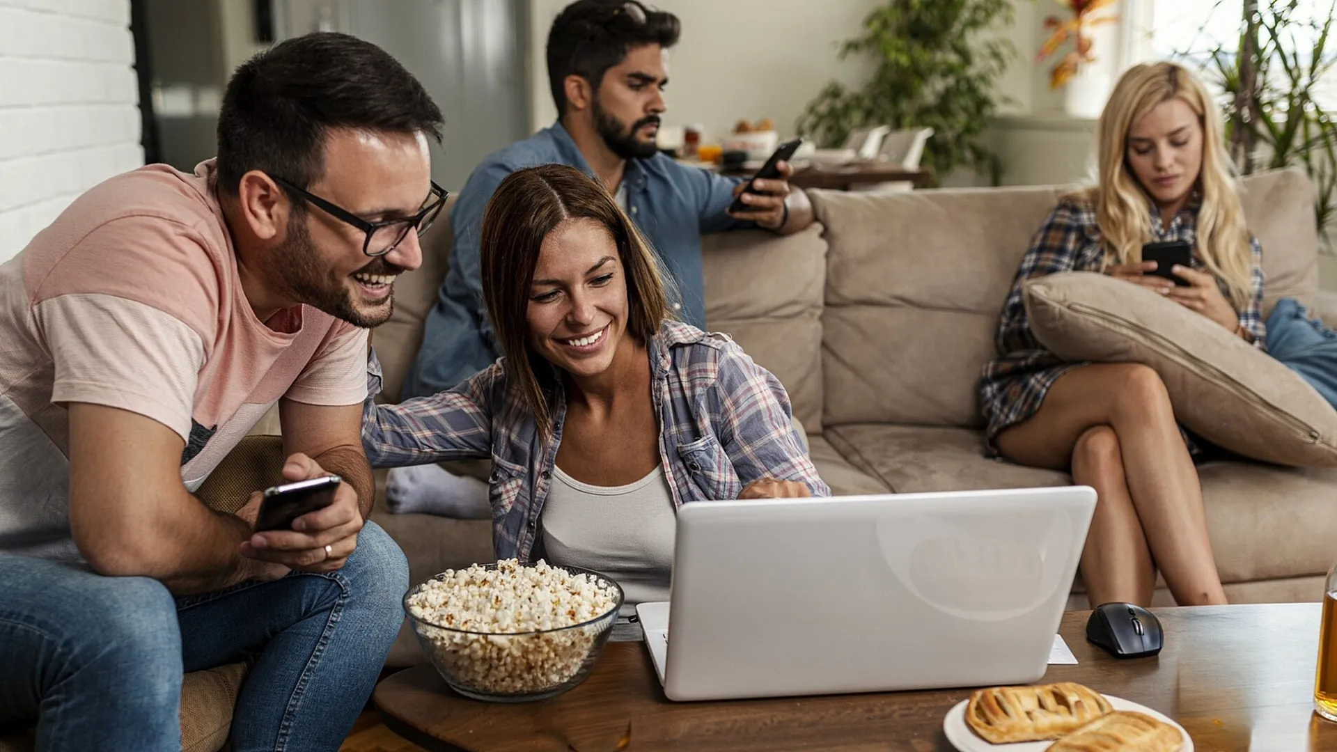 Vibrant living room with friends enjoying a cozy movie night, featuring comfortable seating, snacks, and a sociable atmosphere.
