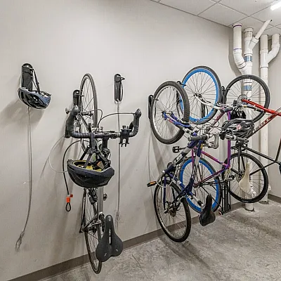 Modern and secure bicycle storage room featuring mounted bike racks and ceiling lighting, ideal for urban living.