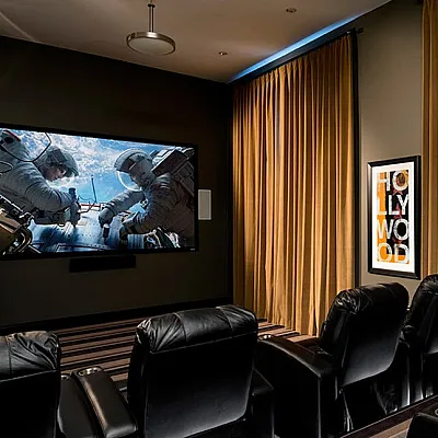 Kensington's luxurious theater with plush leather seating, a large movie screen, and elegant lighting, perfect for an immersive cinematic experience.