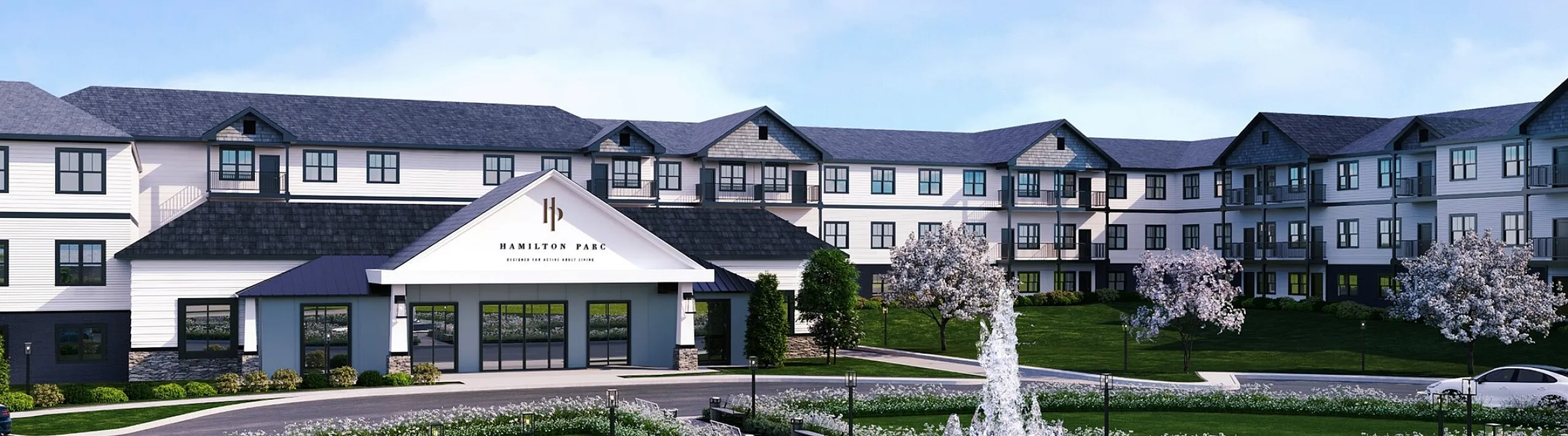 Elegant Hamilton Parc building with modern architecture, featuring beautifully landscaped grounds and a central fountain, perfect for serene living.