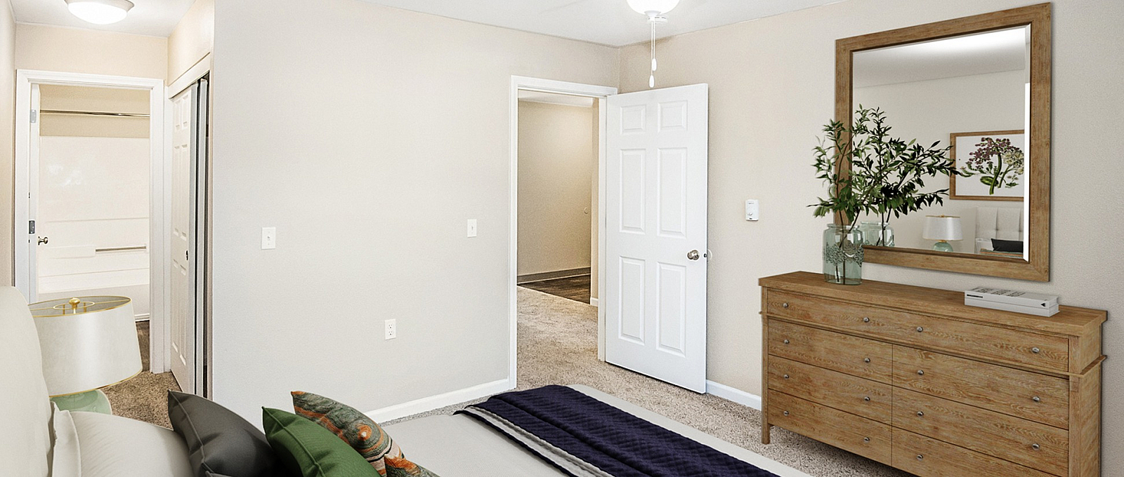 Inviting bedroom with a cozy bed adorned with colorful pillows, elegant wooden dresser, and a fresh interior design.
