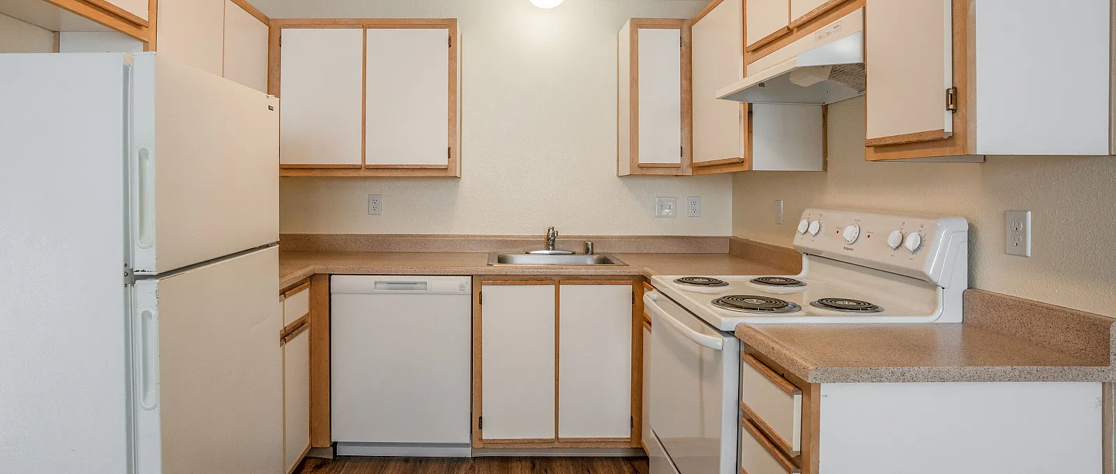 Bright and inviting kitchen with ample cabinetry, modern appliances, and warm wood flooring, perfect for culinary adventures.