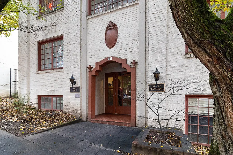 Charming apartment entrance with vintage decor, featuring decorative brickwork and elegant arched doorway.