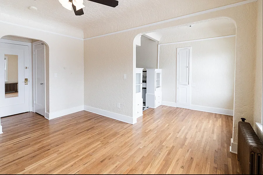 Bright and inviting living space with elegant archways and warm hardwood floors, perfect for stylish city living.