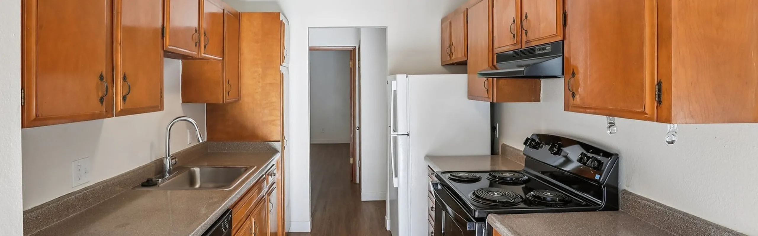 Charming kitchen with warm wood cabinetry, spacious countertops, and sleek modern appliances.