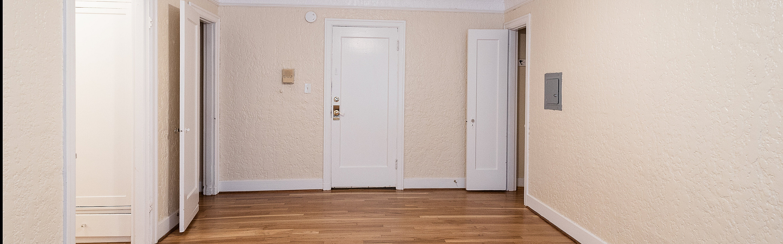 Bright living space with elegant hardwood floors and a ceiling fan, perfect for a stylish apartment in a cozy setting.