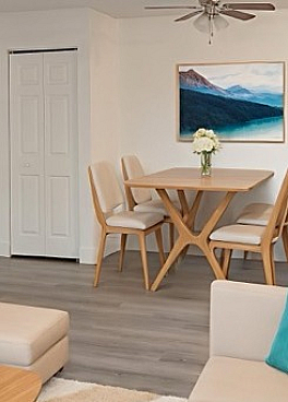 Charming open-concept living area in a virtually staged apartment, featuring a cozy dining nook, modern decor, and a sleek TV setup.