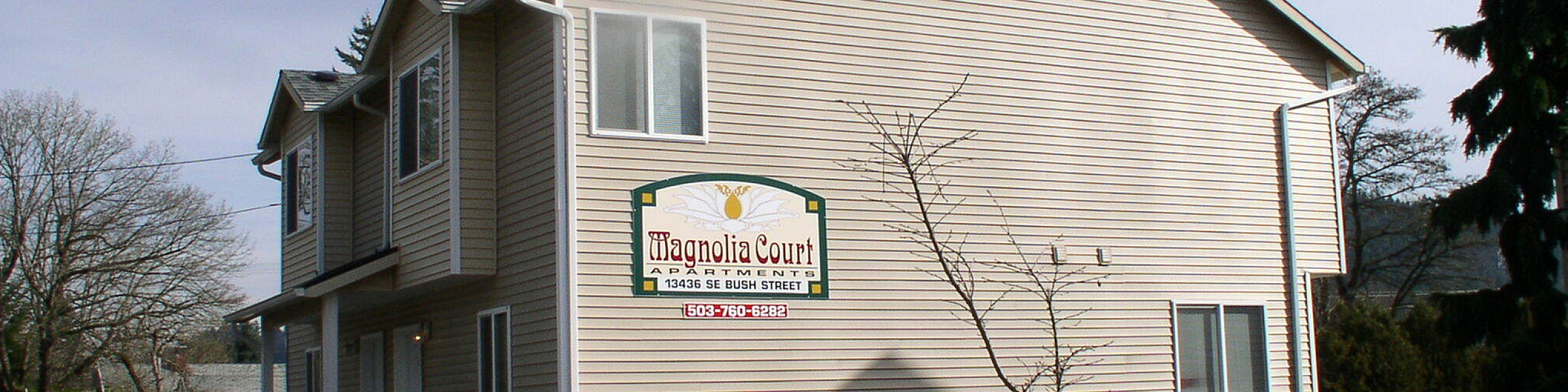 Charming Magnolia Court Apartments with landscaped garden and inviting entrance, perfect for comfortable living.