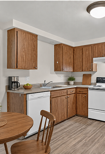 Charming kitchen boasting stylish wooden cabinets, modern appliances, and cozy dining area, perfect for intimate meals.