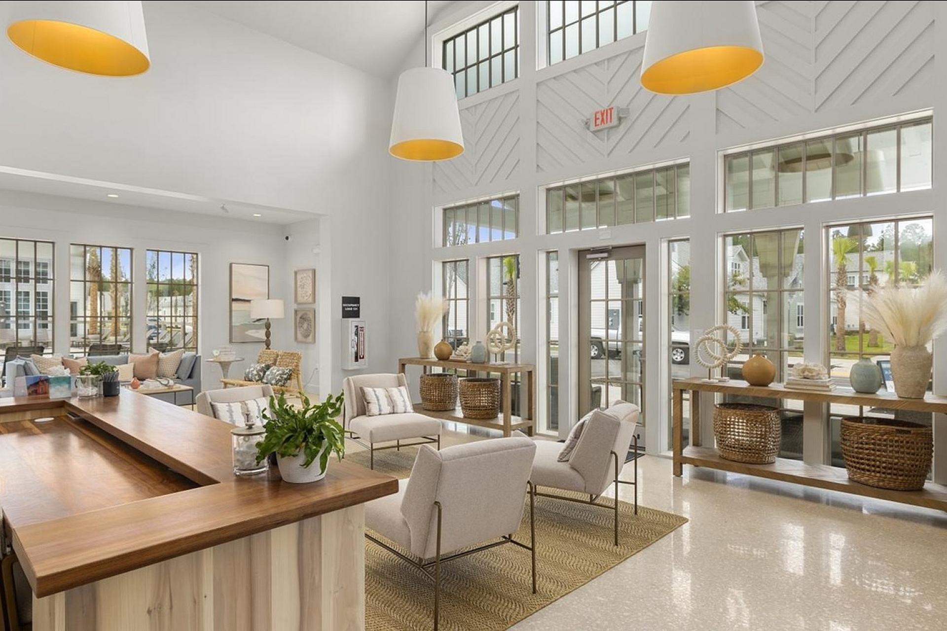 Bright and inviting apartment lobby featuring modern seating, natural wood accents, and large windows filling the space with natural light.