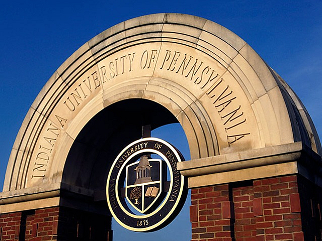 Indiana University of Pennsylvania Arch entrance with a set against a clear blue sky, showcasing timeless architecture.