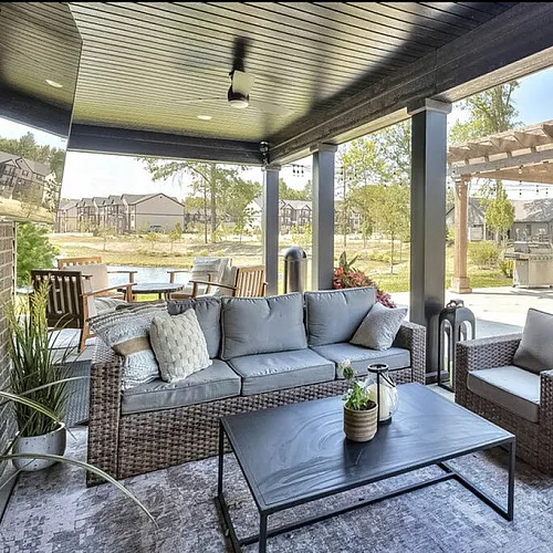Chic outdoor patio featuring comfortable wicker seating, modern decor, and a scenic pergola, ideal for relaxation and entertainment.